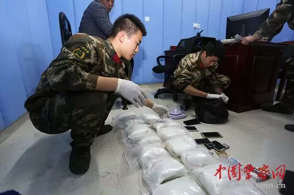 People_s_Armed_Police_look_over_packages_of_drugs_siezed_from_a_smuggler__in_february