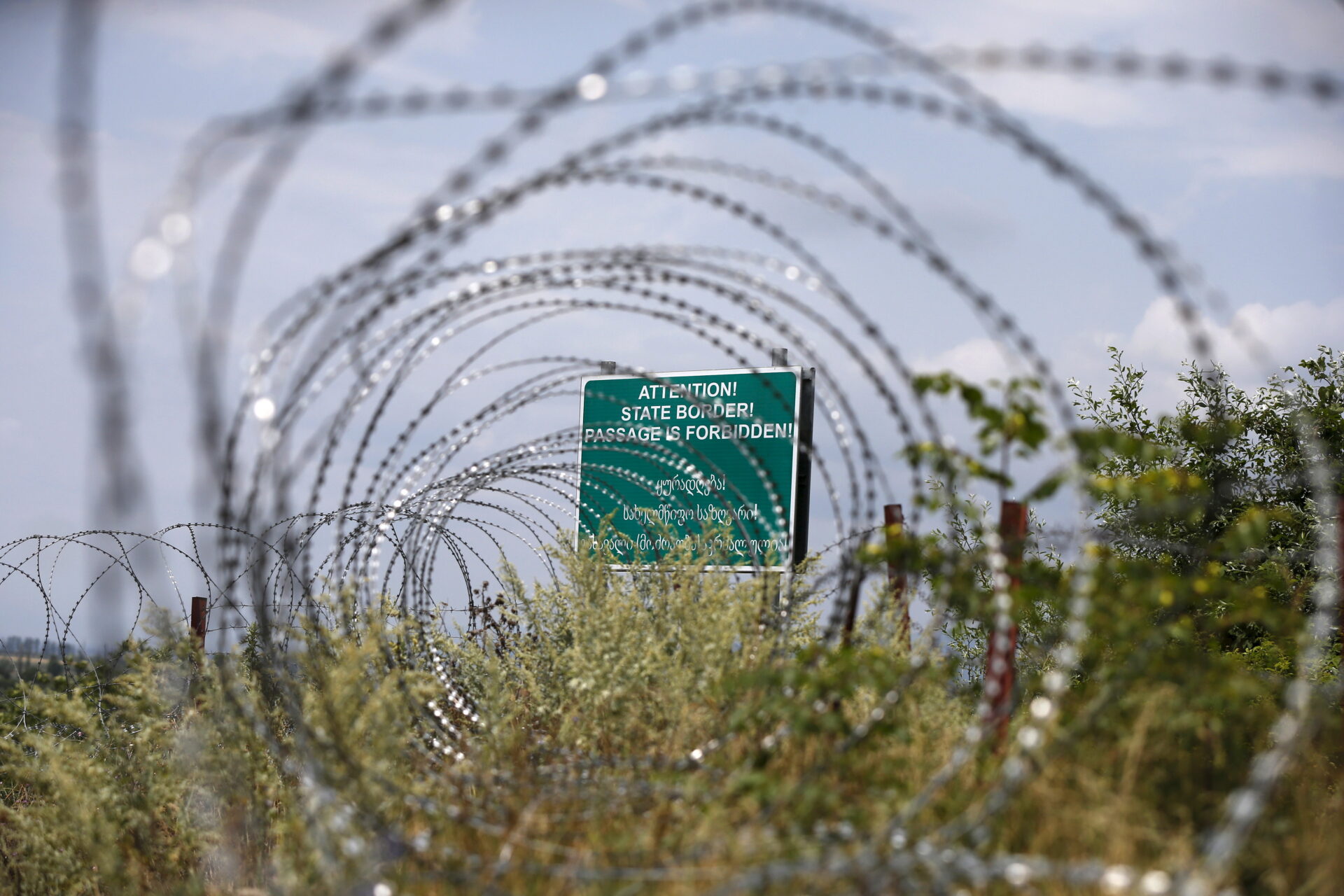 A warning sign is pictured behind a wire barricades erected by Russian and Ossetian troops along Georgia’s de-facto border with its breakaway region of South Ossetia in the village of Khurvaleti